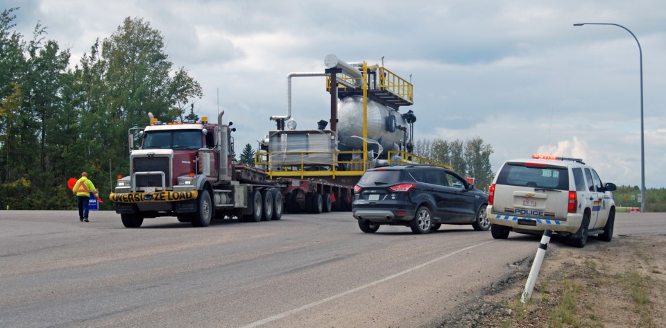 A wide load passes through a traffic safety checkstop outside of Lac La Biche.