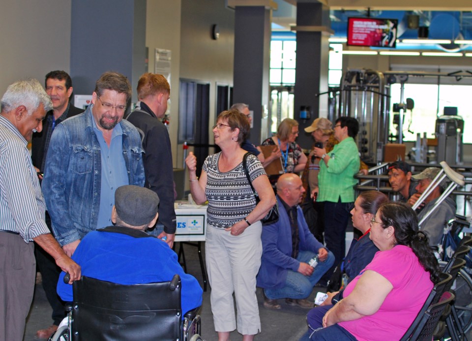 Lac La Biche County&#8217;s Mayor Omer Moghrabi, MP David Yurdiga, Wildrose Party leader Brian Jean and local MLA David Hanson disperse into a crowd of evacuees from Fort