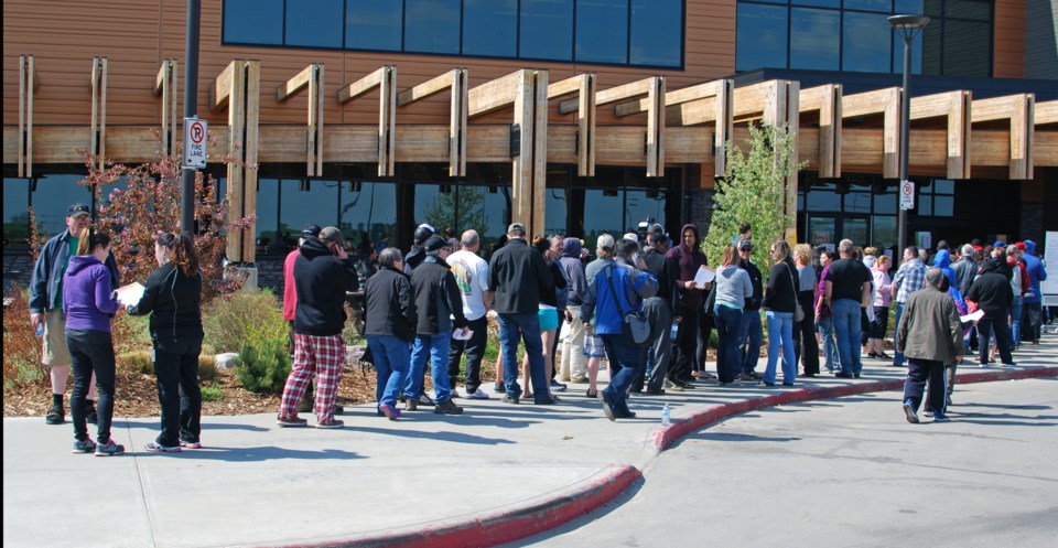 Evacuees line up outside the Bold Center to pick up pre-loaded debit cards with government relief money earlier today.