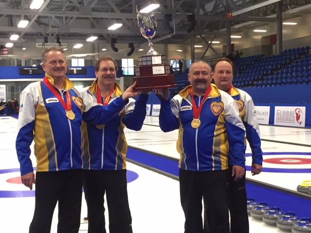 From left to right, lead George White, second Dan Holowaychuk, third Barry Chwedoruk and skip Wade White lift the gold medal trophy after winning the Everest Senior