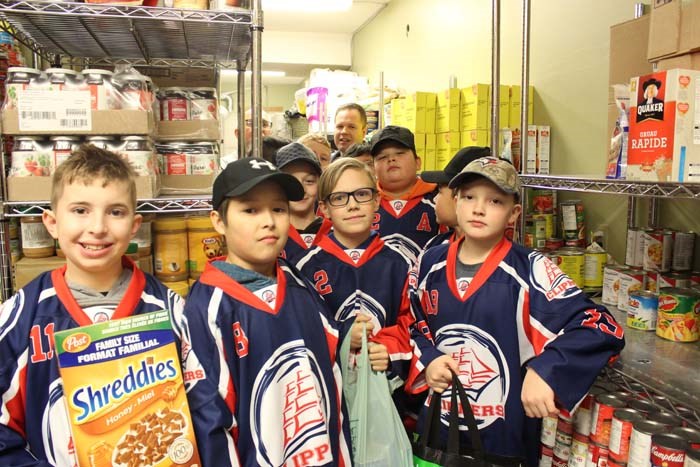 Young Pewee Clippers at the Canadian Native Friendship Centre's food bank storage room.