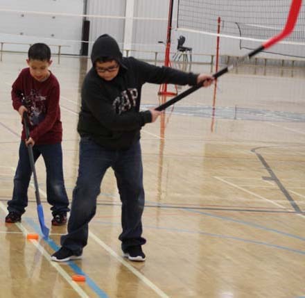  Sammy Marczak teaches his younger brother Kolton Marczak how to shoot the puck