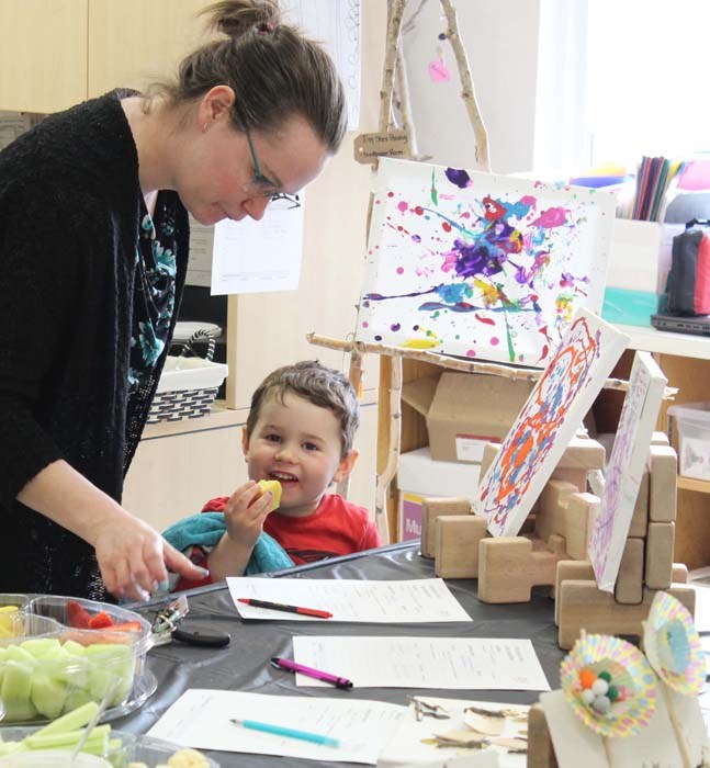  Aimee Donovan picks up a pen to bid at the Art Walk's silent auction as Alex Donovan smiles for the camera