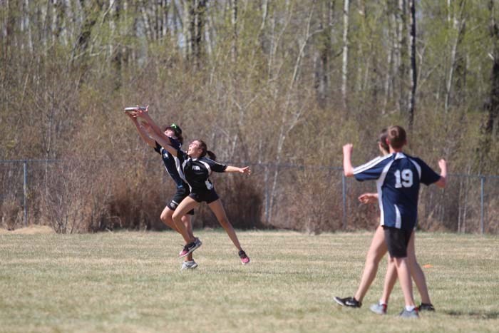  Zone 6 and Zone 8 ultimate frisbee players trying to reach for the spinning frisbee at the KC grounds