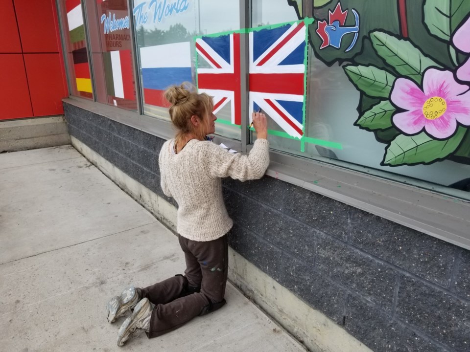  Simone Page painting the Union Jack on Britton's Independent Grocery store in Lac La Biche — That's one of the 25+ countries whose athletes will be competing in the World Archery 3D Championships in Lac La Biche from Sept 2-7  : Photo — Paul Arsenault