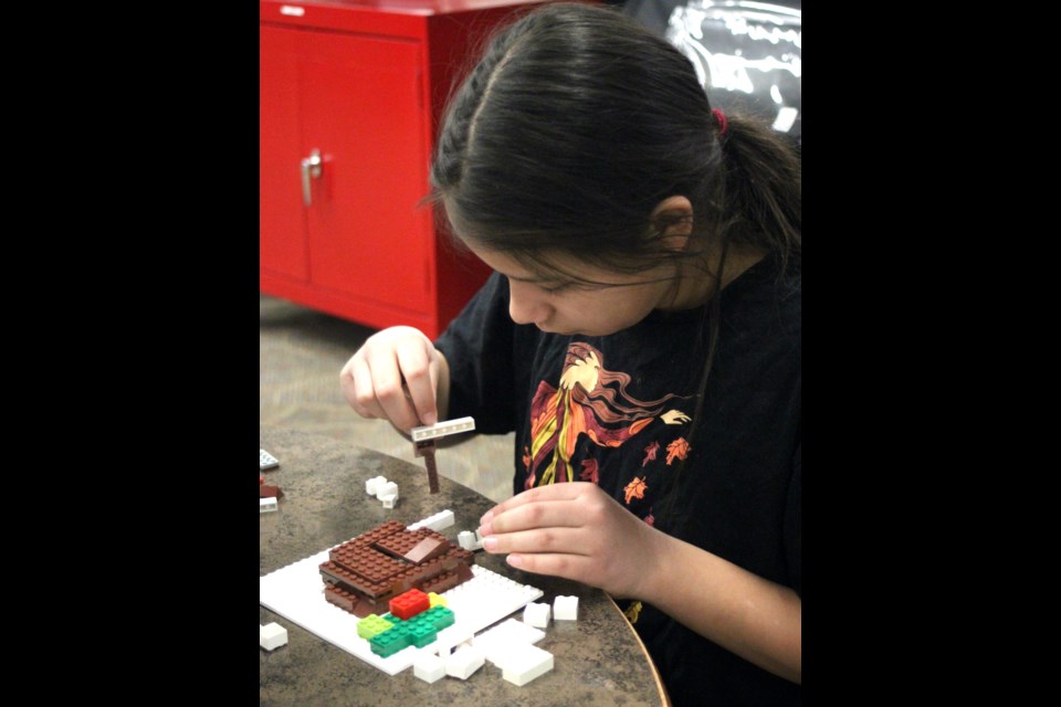 Kara Thompson works on a LEGO creation at the Stuart MacPherson Public Library. Chris McGarry photo.