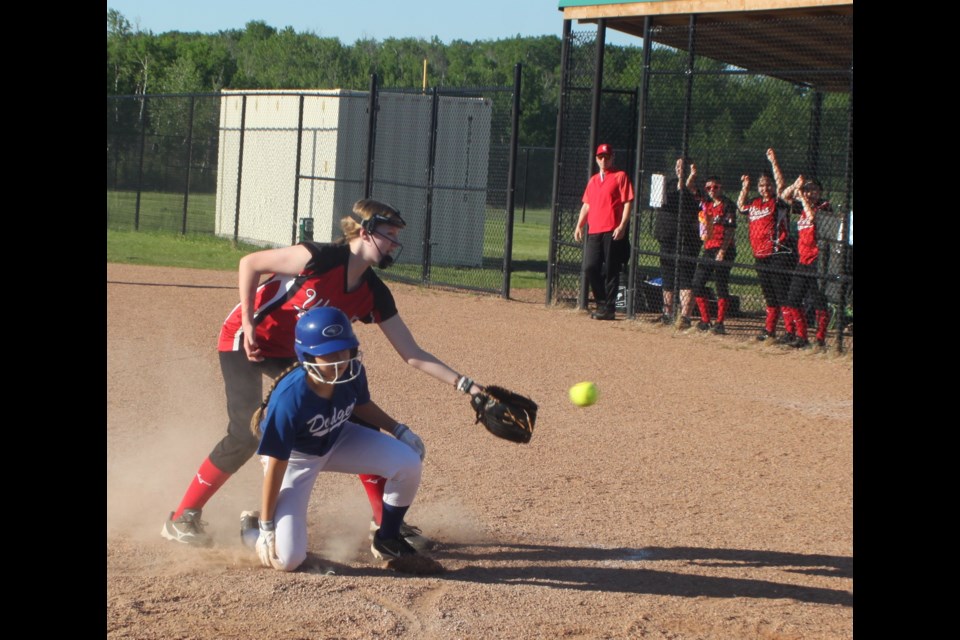 Members of the Cold Lake Wildcats watch as Lac La Biche Dodgers player Kaylin Beniuk slides into home plate before Wildcats pitcher Ainsley Hipkins has the opportunity to tag her. Chris McGarry photo. 