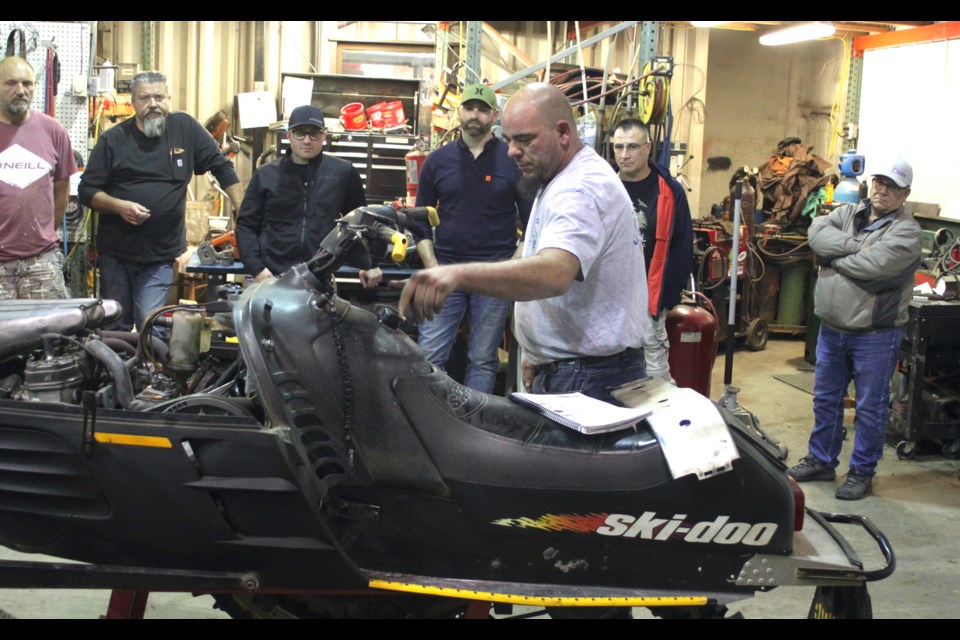 Rob Kruk goes over some basic maintenance of a snowmobile during this week's general meeting of the Lac La Biche Back-county Riders. There's no snow on the ground ... yet — but it's coming.