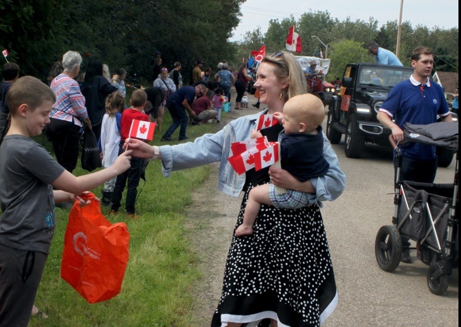 Laila Goodridge, Member of Parliament for Fort McMurray-Cold Lake, hands out flags during the 2024 Hylo Harvest Days parade. Chris McGarry photo. 