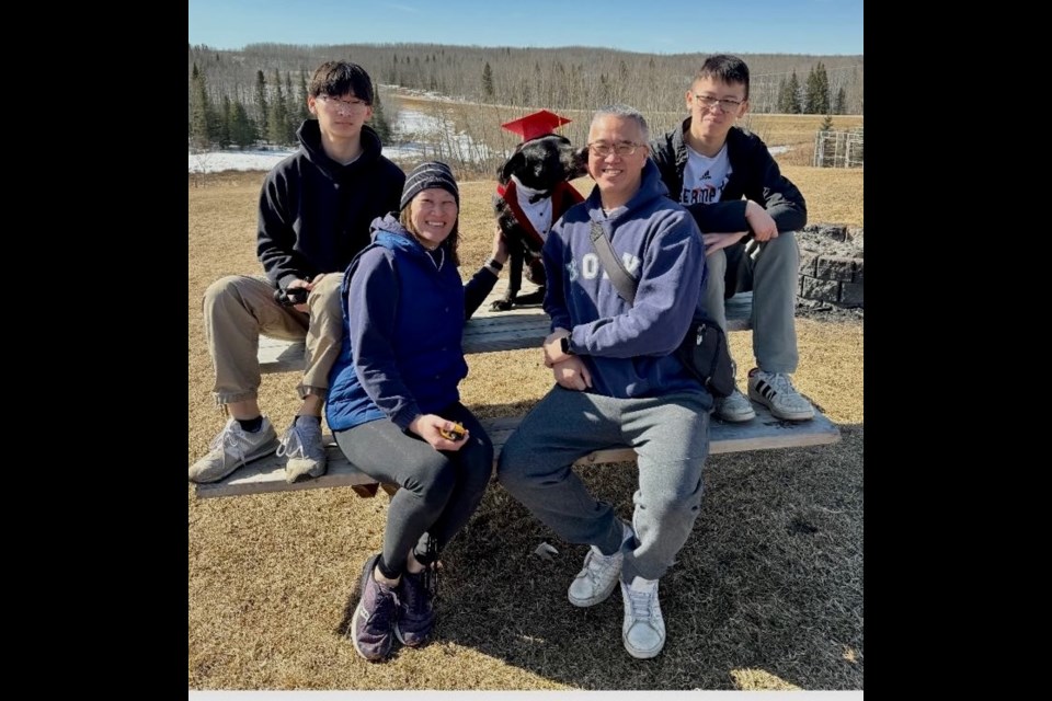 Wayne Mah, his wife, Jen, and sons Keenan and Brennan with a dog from the local animal shelter that the family has been fostering since last year. Photo supplied. 