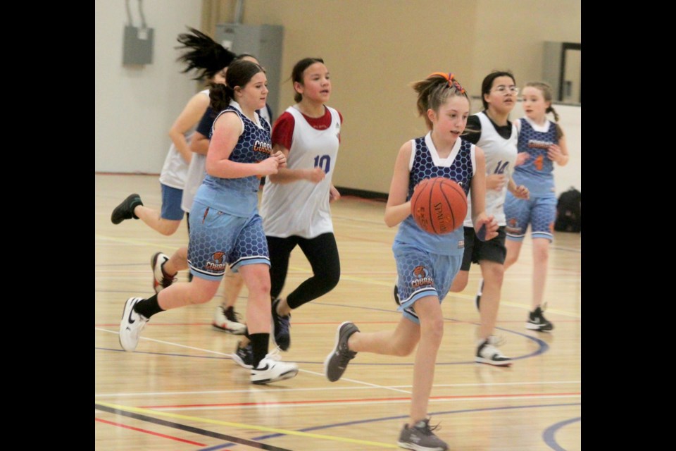 After gaining possession of the ball, Cold Lake Junior High guard McKinnley Simard moves quickly down the court towards the Aurora net. Chris McGarry photo. 