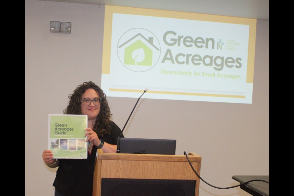 Milena McWatt, the conservation and stewardship program manager with the Edmonton-based Land Stewardship Centre, displays the organization’s Green Acreages Guide workbook during the workshop at McArthur Place on July 8. Chris McGarry photo. 