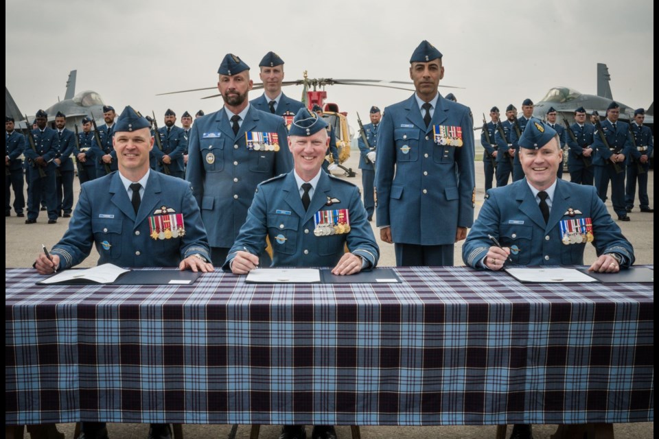 Col. David Turenne, outgoing 4 Wing Commander, Brigadier-General Paul Doyle, Deputy Commander, 1 Canadian Air Division, and Colonel Mark Hickey, incoming 4 Wing Commander sign documents during the 4 Wing Cold Lake change of command ceremony at 4 Wing Cold Lake, Alberta, on July 25.
Photo credit: Master Corporal Angela Gore, Royal Canadian Air Force Imagery Technician (4 Wing)