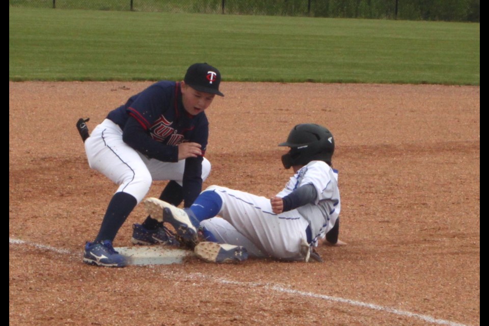 Jaxon Erasmus of the 15U AA Lac La Biche Dodgers is confronted by Lincoln Valinquette of the Parkland Twins as he slides into third base during the recent home game weekend. The Dodgers won 11-8. Chris McGarry photo. 