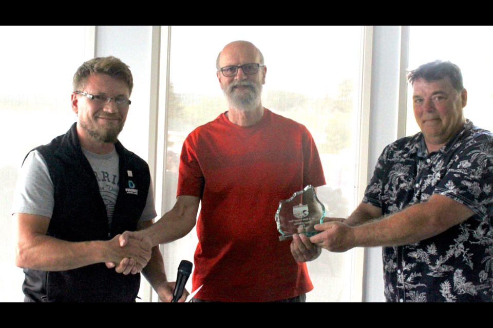 Paul Shaw, a retired long term care nurse who had devoted the past ten years of his life to various volunteering pursuits around the community, graciously accepts the Citizen of the Year award from Lac La Biche County mayor Paul Reutov and Neil Timm, president of Lac La Biche Summer Days. Chris McGarry photo.