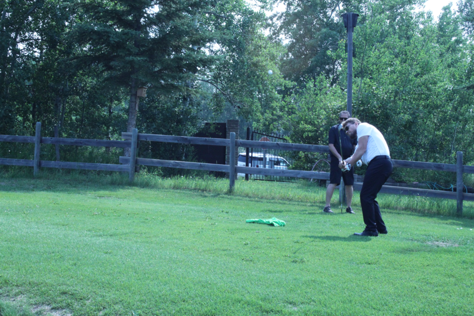 Paul Reutov, mayor of Lac La Biche County, chips one back onto the short stuff from behind the green on 18 during the annual Healthier Communities Golf Tournament, which took place earlier in July at the Lac La Biche Golf and Country Club. Chris McGarry photo. 