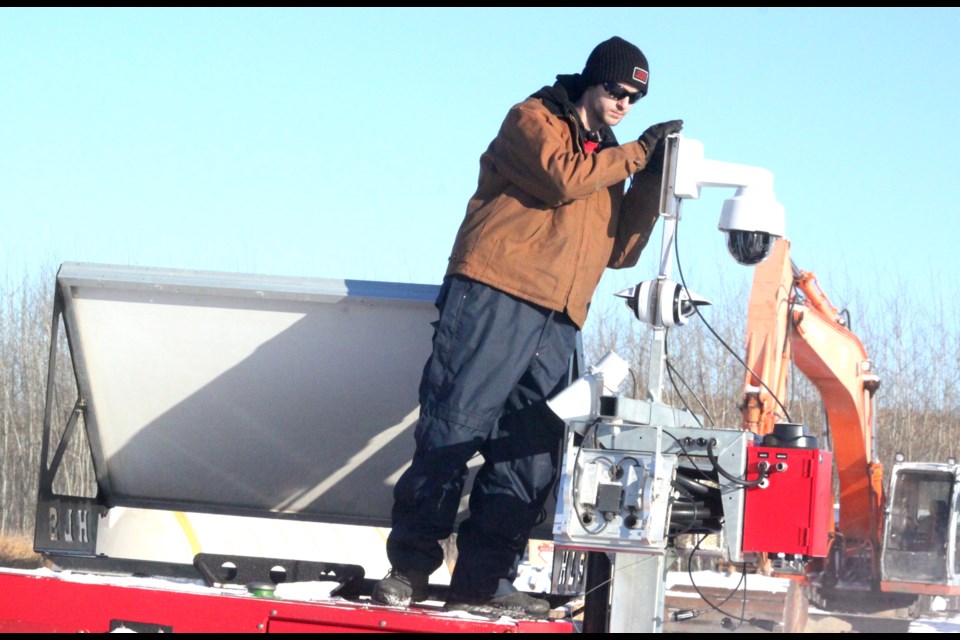 Peyton Ziniuk of Zedcor Security bundled up against the frigid cold as he installed a security camera. Chris McGarry photo. 