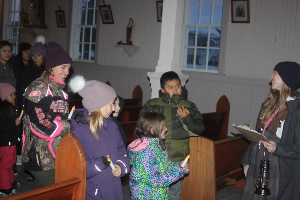 Phoenix Murphy led the spooky guided tour of the Lac La Biche Mission in the dark, which took place Friday evening. Here, she chats with members of the tour group about the history of the church on the Mission grounds. Chris McGarry photo.