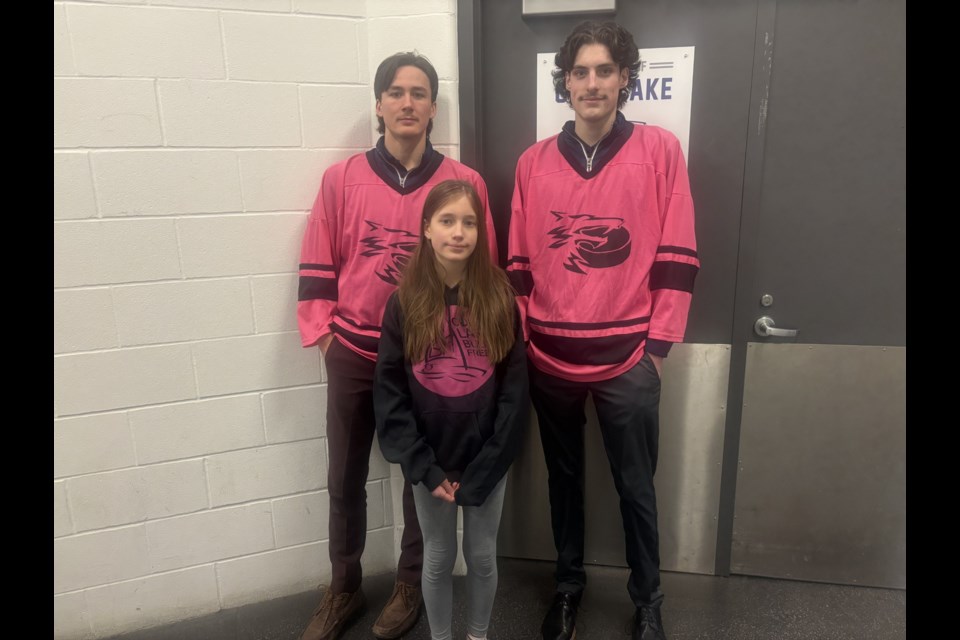 Alexa Williams poses for a photo with Cold Lake Junior B hockey players Kamden Brunet (left) and Josh Hache (right) before the game at Imperial Oil Place Arena.
