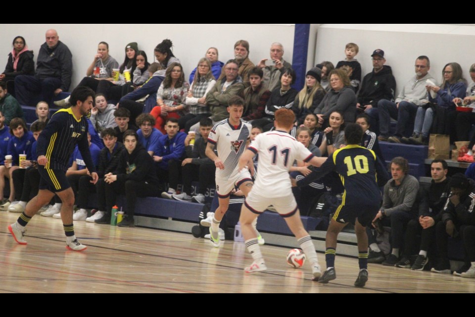 The crowd watches as Victor Lourenco of the Portage College Voyageurs moves towards the NAIT Ooks zone while trailed by an opponent. The game resulted in a 1-1 tie. Chris McGarry photo. 