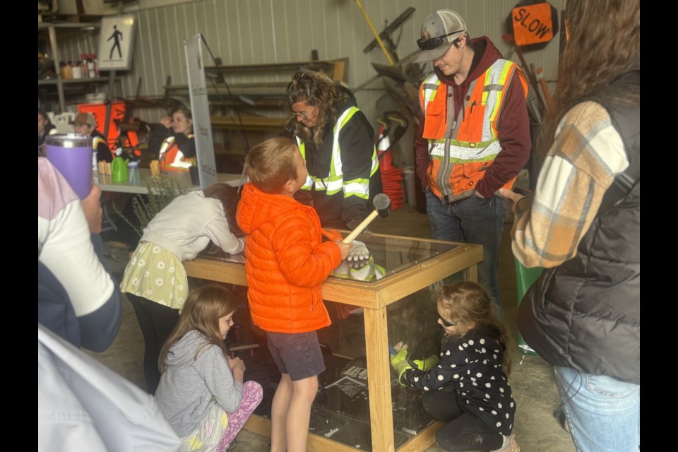Families played the activity of smashing electronics inside of a box with hammers.