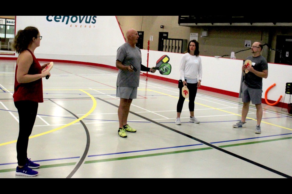 Rob Barrett speaks with some of the attendees at the clinic before showing them how to properly handle a pickleball paddle. Chris McGarry photo. 