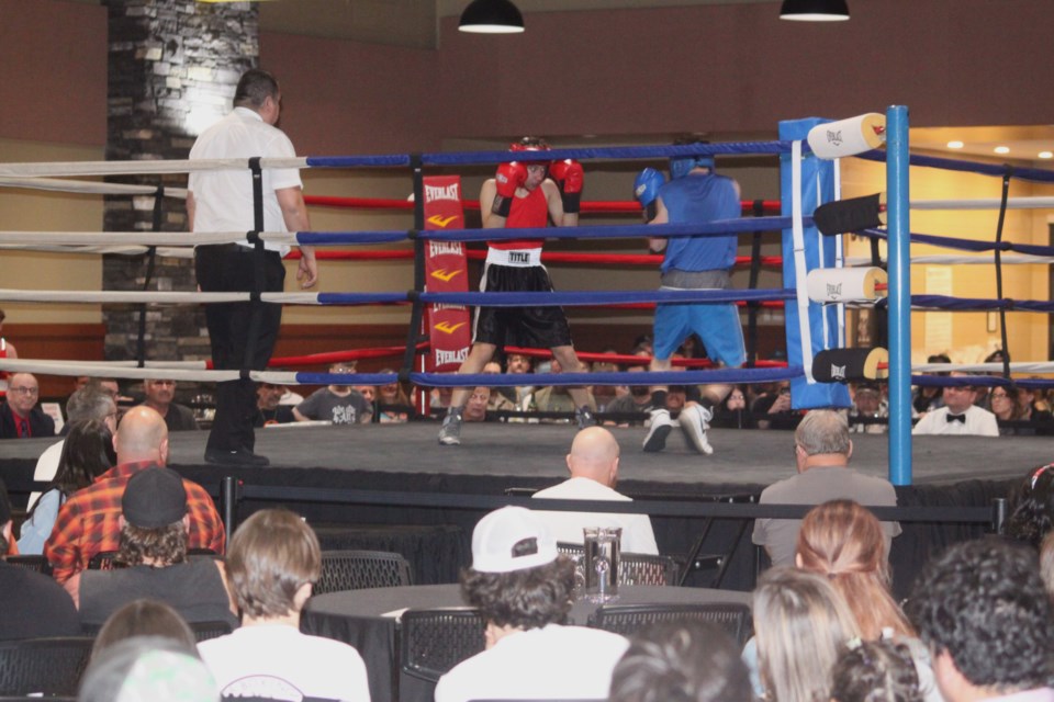 Rory Mcharg (in blue) of the Lac La Biche Boxing Club faces off against Charlie Jaworek, who was representing the Cougar Boxing Club of Edmonton at the locally-held fight card. Chris McGarry photo.