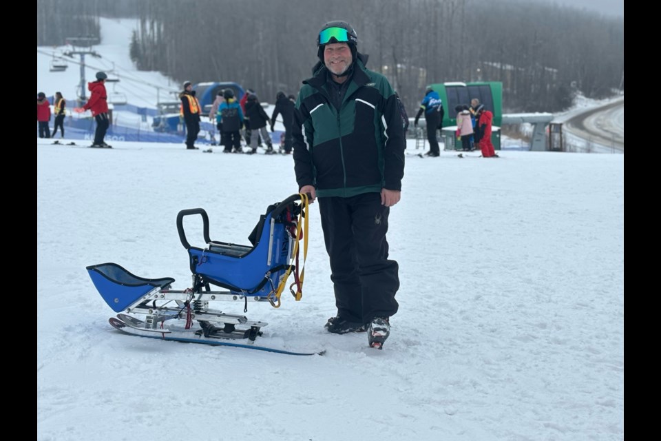 Vice president of CADS Alberta, Chris Holoboff setting up an adult Bi-Ski.