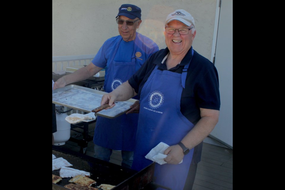 Andy Gesner and Tim Polzin, members of the Rotary Club of Lac La Biche, fry up some fish for the meal. / Chris McGarry photo. 
