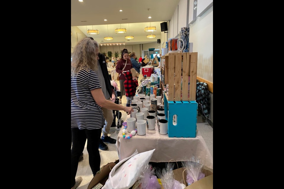 Tina Paananen, owner of Whimsical Creations in Cold Lake, picture on left, at a local market. Her company creates designs for various items, including mugs, glasses, and tumblers. Submitted photo. 