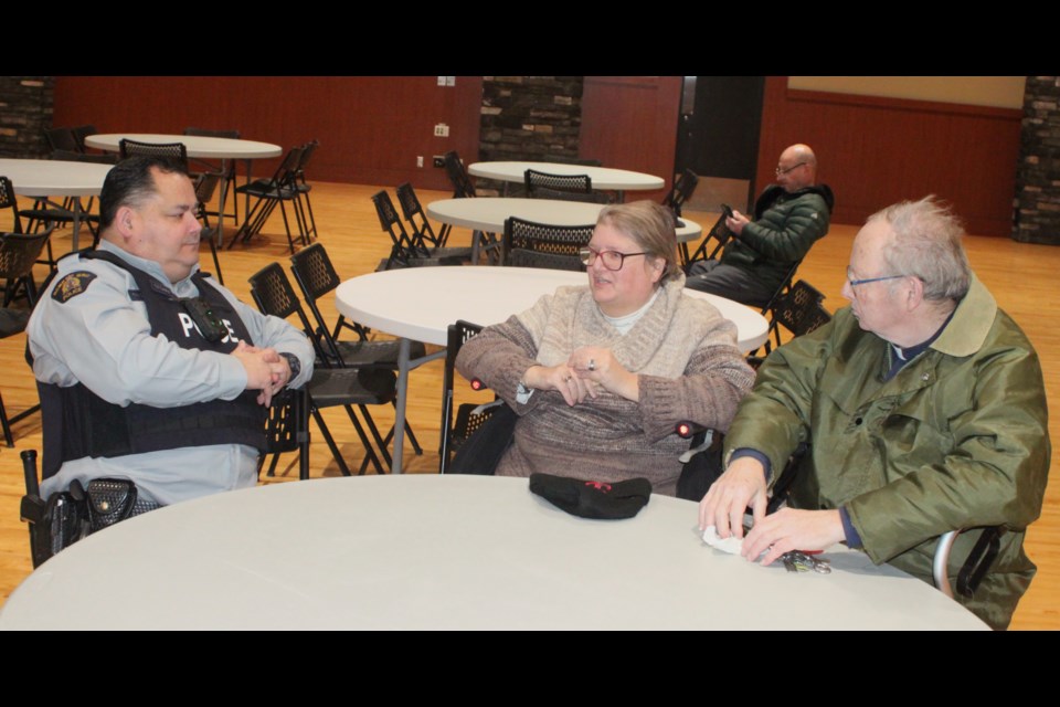 Sgt. Trevor Cardinal, acting commander of the Lac La Biche RCMP detachment, talks with Kevin and Kathryn Pederson, who came to the RCMP townhall at the Bold Centre Community Hall on Feb. 19. The meeting was put on for residents to voice their concerns about crime and other issues in the Lac La Biche area. Chris McGarry photo. 