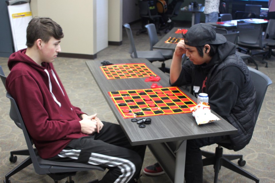 Tristan Germain faces off against opponent Tony Delorme during the checkers tournament. Chris McGarry photo. 
