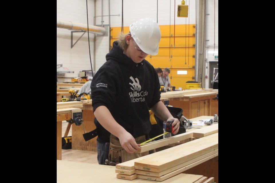 Wyatt Gehring, a student at St. Paul Regional School, measures a board during the carpentry competition that took place at Portage College on March 21 for the 2024 North East Regional Skills Canada Competition. Gehring was part of the group of high school students who took part in the carpentry, welding, and hairstyling competitions. Chris McGarry photo. 