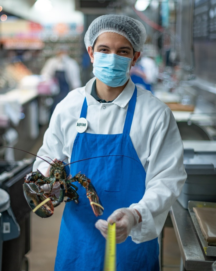 Grocery store employee holding a lobster