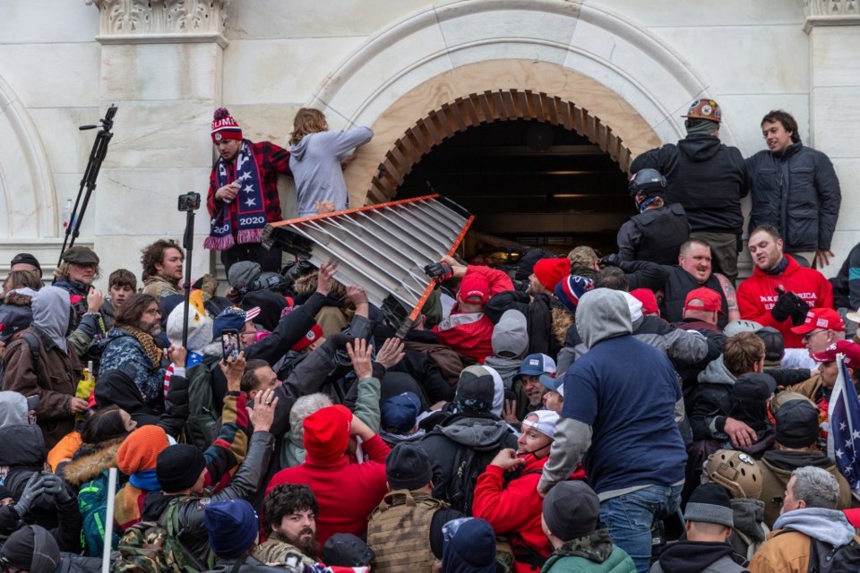 capitol rioters shove a ladder through a window