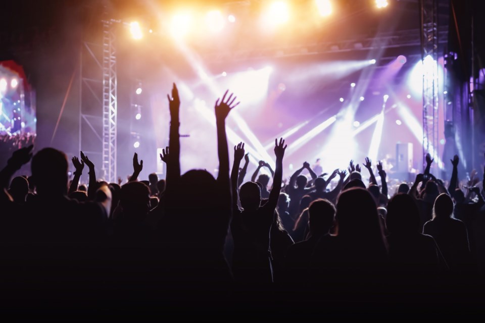 Rock,Concert,,Cheering,Crowd,In,Front,Of,Bright,Colorful,Stage