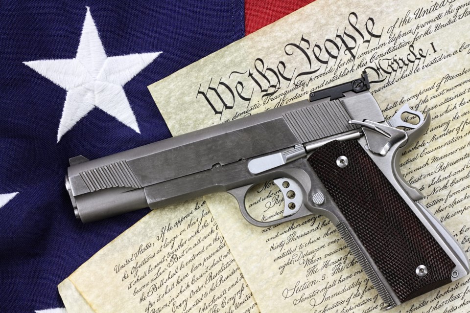 Handgun,Lying,Over,A,Copy,Of,The,United,States,Constitution