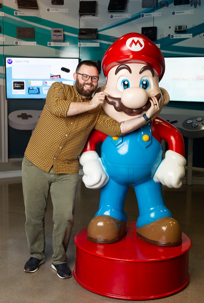 Local influencer, Brandon Does Dallas poses with Mario at the National Video Game Museum in Frisco | Image by Alyssa Vincent. National Video Game Museum is one of the best museums around.