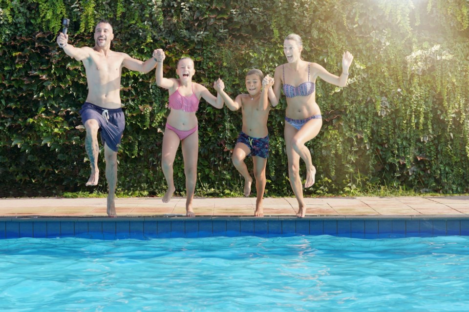 Cheerful,Family,Jumping,In,Swimming-pool