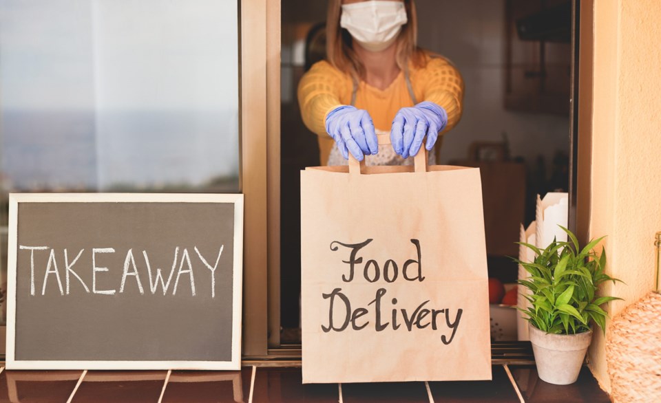 Woman,At,Work,Holding,Delivery,Paper,Bag,With,Food,While