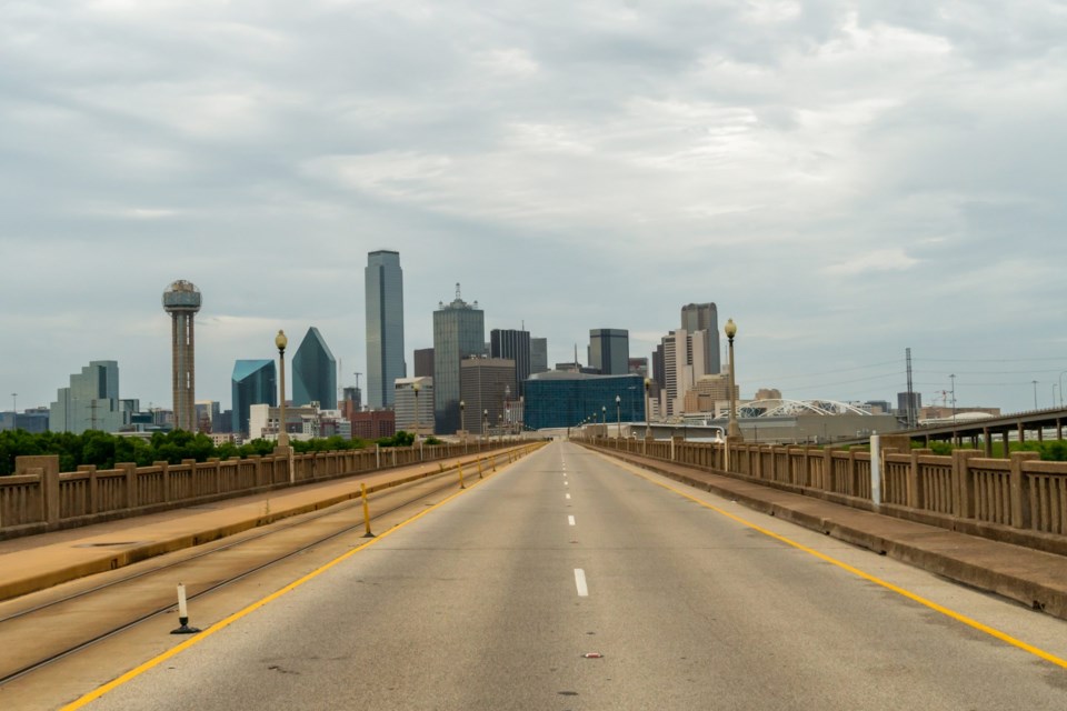 Dallas,Skyline,From,Empty,Highway,With,Dense,Clouds,On,The