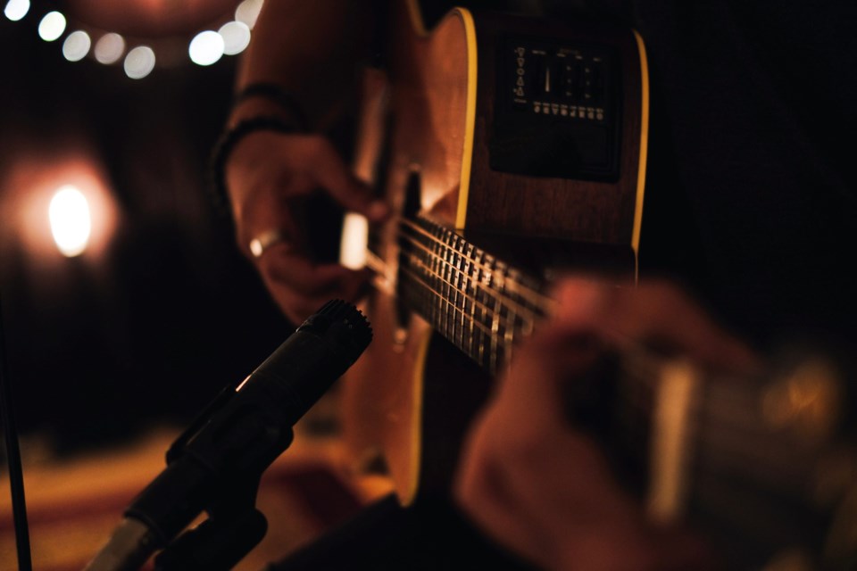 A,Man,Playing,Acoustic,Guitar,In,Recording,Session,With,Microphone