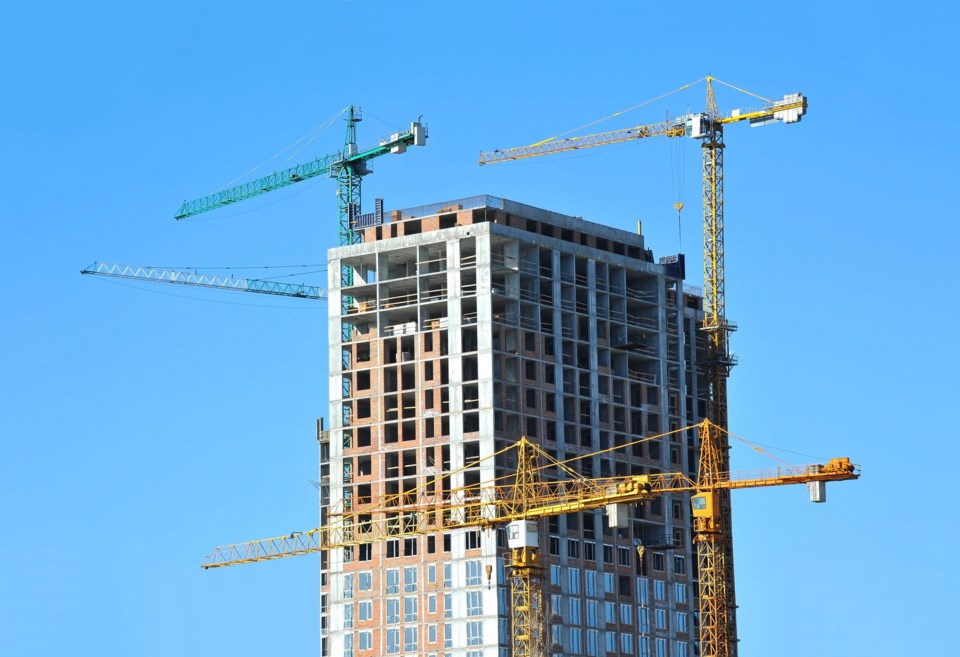 Crane,And,Building,Under,Construction,Against,Blue,Sky