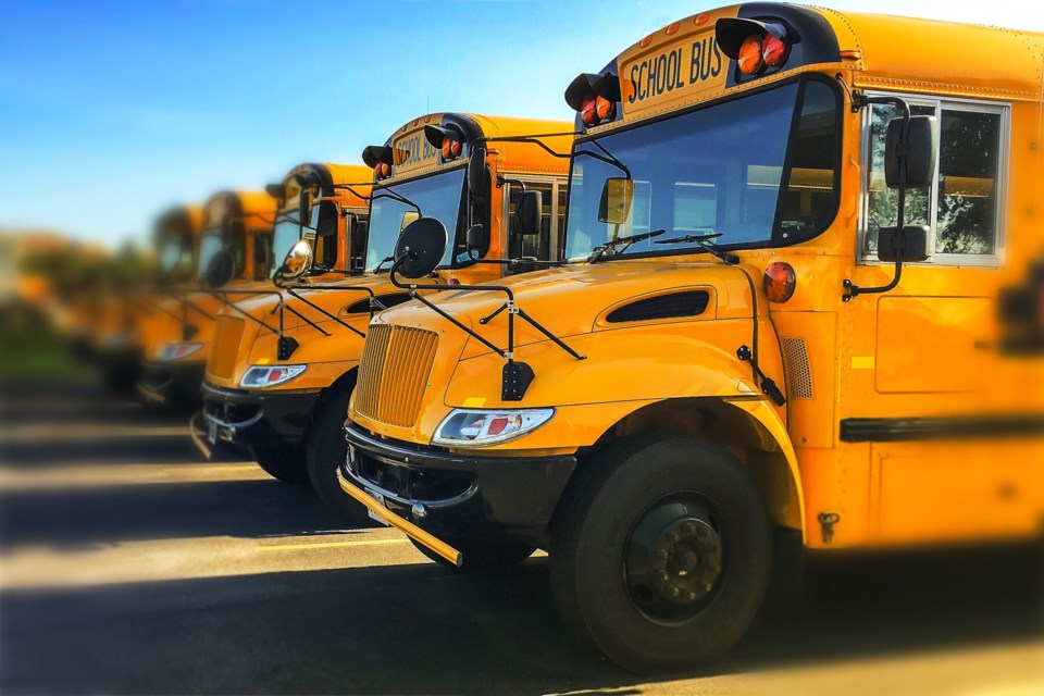 Row,Of,Yellow,School,Buses,Parked,Inline,With,Blurred,Background