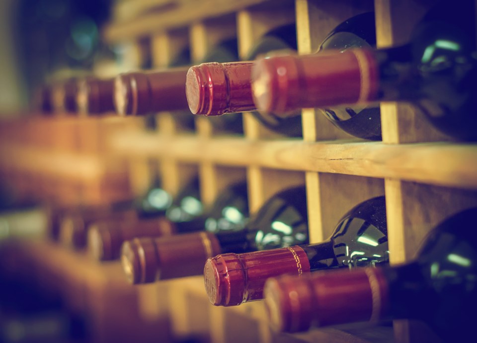 Red,Wine,Bottles,Stacked,On,Wooden,Racks