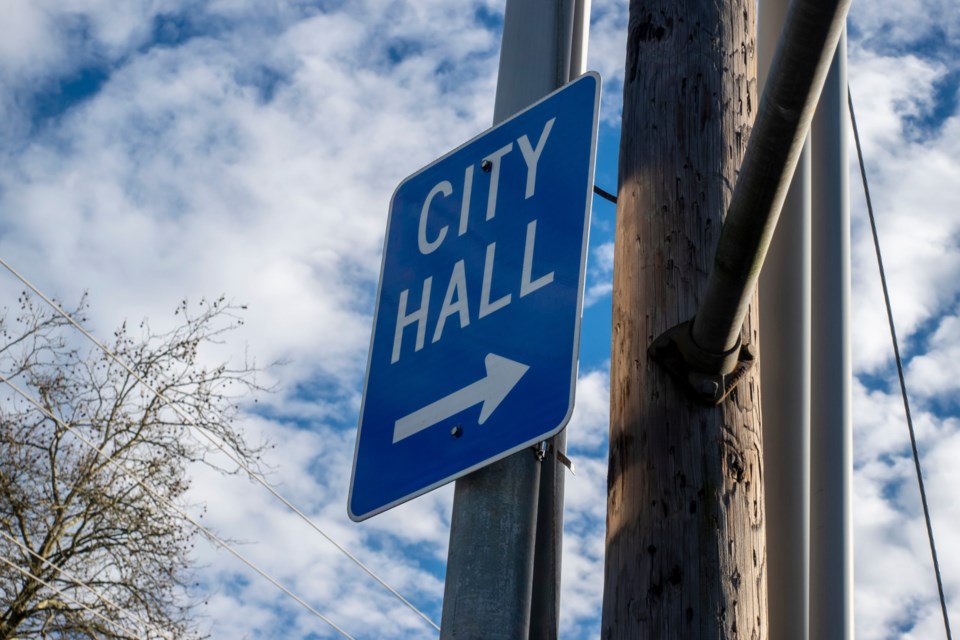Low,Angle,View,Of,A,Blue,City,Hall,Directional,Sign,
