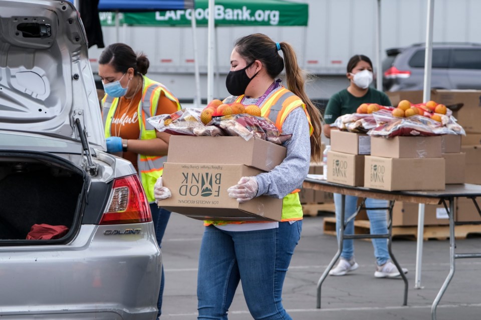 A,Volunteer,Loads,Food,Into,The,Trunk,Of,A,Vehicle