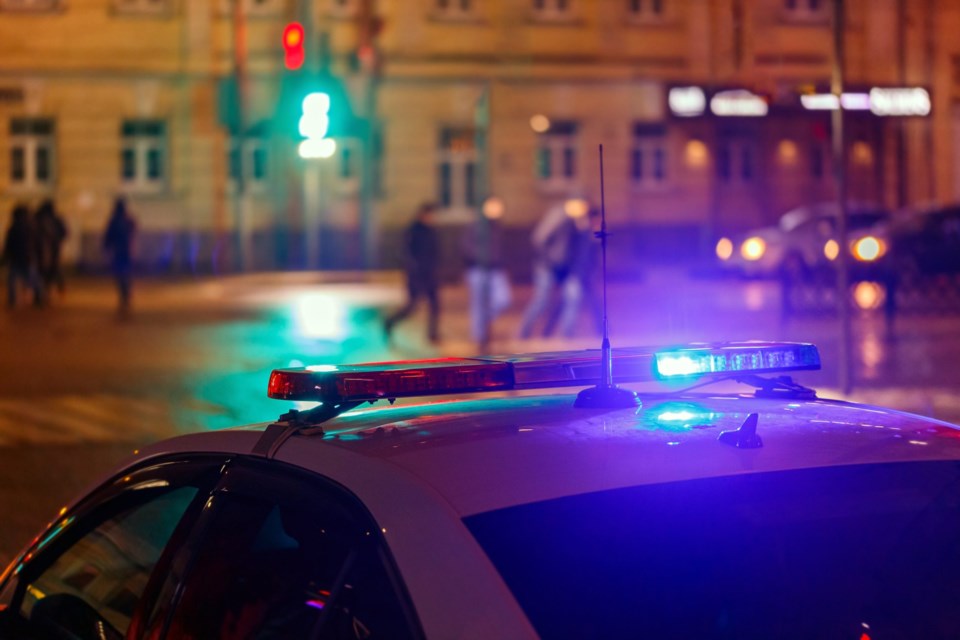 Night,Police,Car,Lights,In,City,Street,With,Blurry,Pedestrians