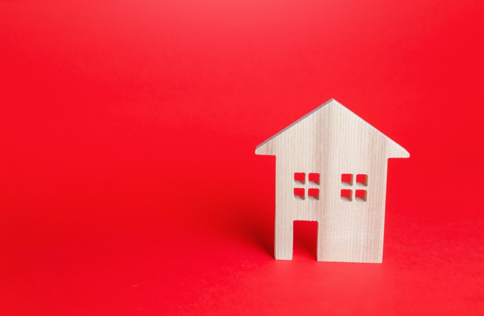 Wooden,House,On,Red,Background.,Buying,And,Selling,Real,Estate.