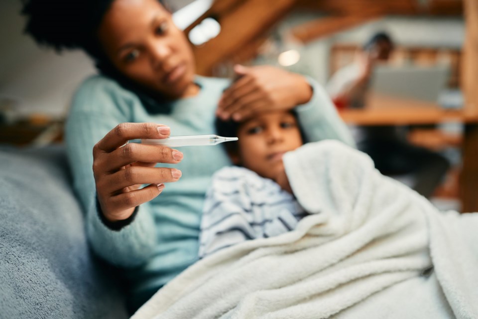 Close-up,Of,African,American,Mother,Using,Thermometer,And,Measuring,Temperature